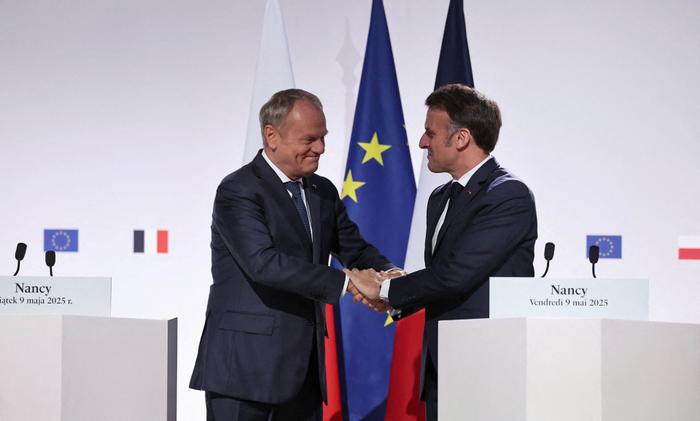 Le Premier ministre polonais Donald Tusk et le président français Emmanuel Macron se serrent la main lors d'une conférence de presse conjointe après la signature du Pacte d'amitié et de stratégie franco-polonais, à l'issue de leur rencontre à Nancy, le 9 mai 2025.