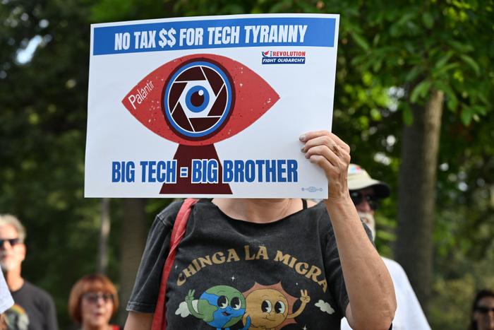 Une personne brandit une pancarte contre la société Palantir lors d'une manifestation le jour de la fête du travail aux Etats-Unis.