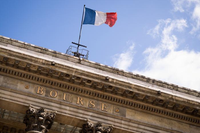 Le drapeau français flottant sur l'ancien siège de la Bourse de Paris, ou Palais Brongniart, à Paris. (Photo : Miguel Medina / AFP)