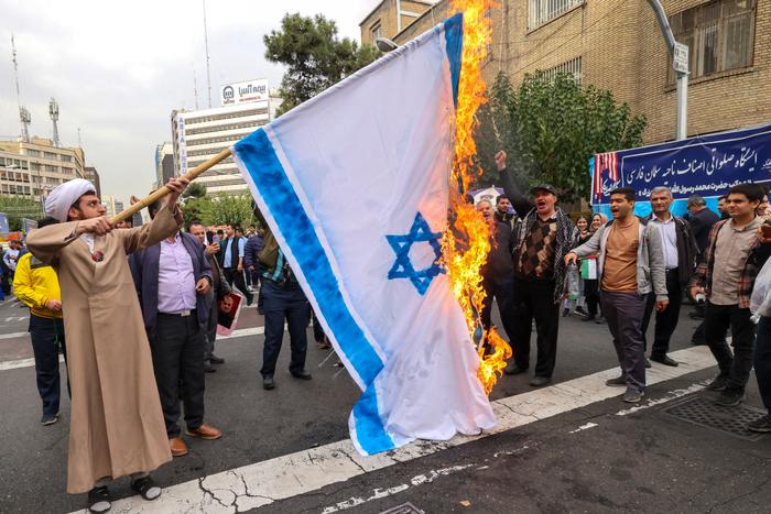 Des gens brûlent un drapeau israélien lors d'un rassemblement devant l'ancienne ambassade des États-Unis à Téhéran, alors que les Iraniens commémorent le 45e anniversaire du début de la crise des otages en Iran, le 3 novembre 2024.