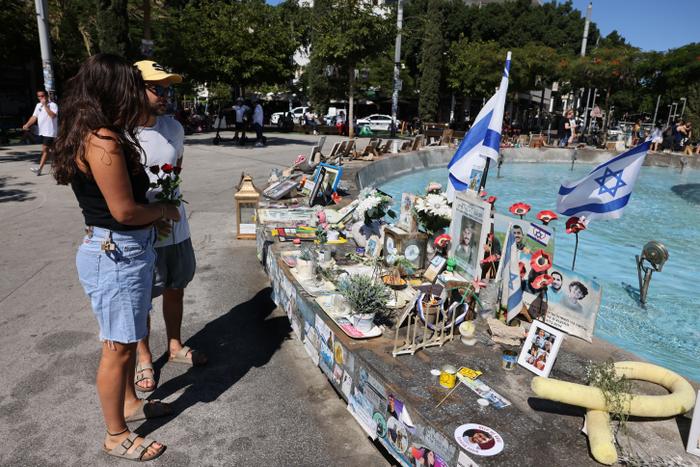 Des gens portent des roses pour les déposer au mémorial de Tel Aviv en l'honneur des Israéliens tués pendant et au cours des deux années qui ont suivi les attaques de 2023 par des militants palestiniens, le 7 octobre 2025.