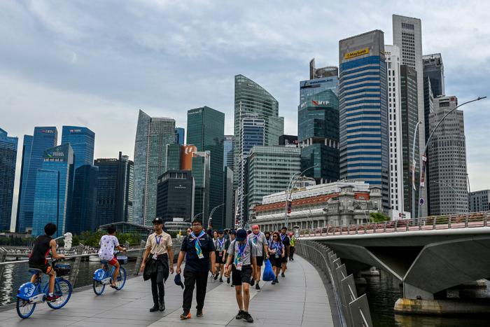 Des personnes traversent le pont Jubilee, sur le front de mer de Marina Bay à Singapour, le 21 novembre 2025.