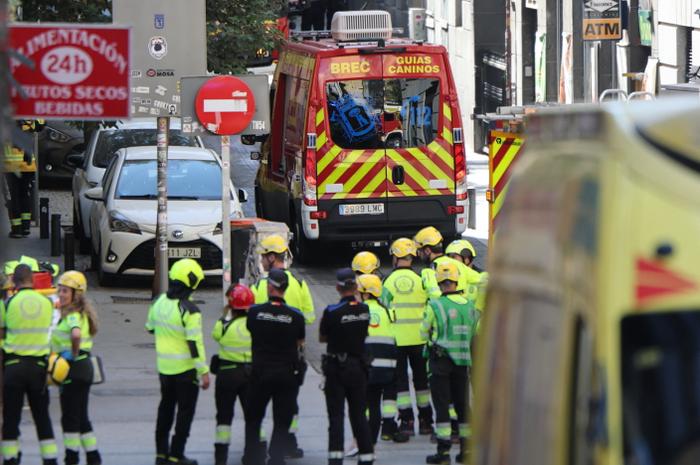 La police et les services d'urgence se rassemblent près du site de l'effondrement d'un immeuble à Madrid le 7 octobre 2025.