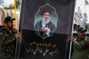 Des membres du Hachd al-Chaabi (Forces de mobilisation populaire – FMP) arborent une bannière à l'effigie du guide suprême iranien, l'ayatollah Ali Khamenei, lors d'une procession funéraire à Bagdad le 8 mars 2026.