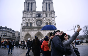 Des touristes qui profitent du bonheur de redécouvrir la cathédrale Notre-Dame de Paris après sa réouverture.