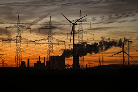 Des éoliennes et des pylônes électriques près des tours de refroidissement de la centrale thermique au lignite exploitée par le géant énergétique allemand RWE près de Neurath, dans l'ouest de l'Allemagne.