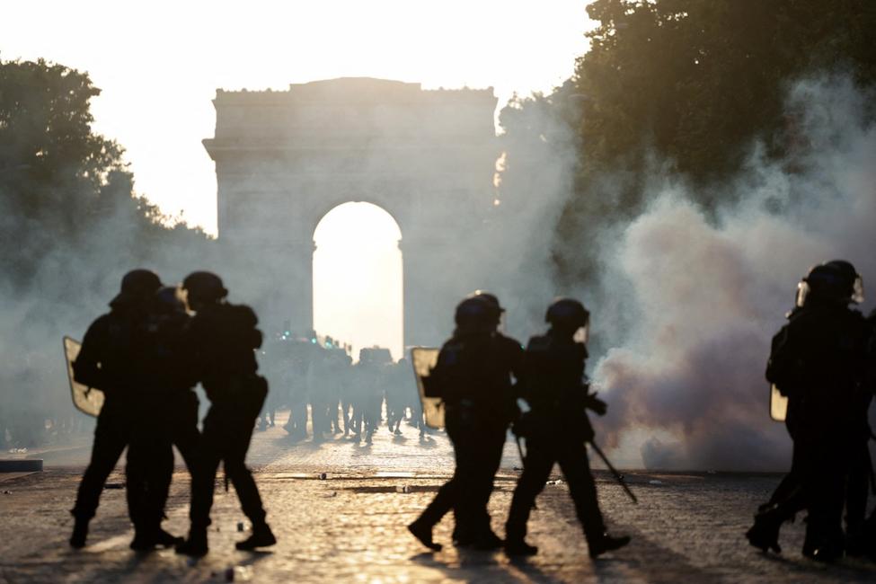 Des CRS marchent au milieu de la fumée des gaz lacrymogènes sur l'avenue des champs-Élysées, après le match de football entre le Paris Saint-Germain (PSG) et l'Arsenal FC joué à Budapest, le 30 mai 2026.