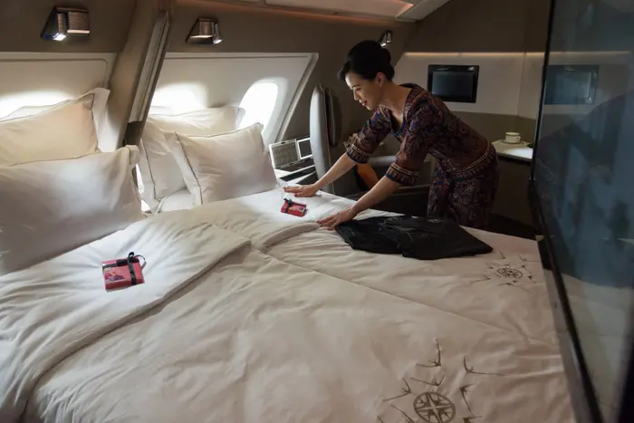 Une hôtesse de l'air arrange les draps d'un lit double dans une suite du nouvel Airbus A380 de Singapore Airlines à l'aéroport de Changi, à Singapour.