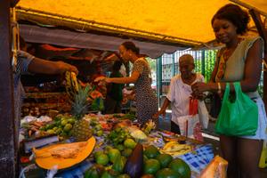Des clients achètent des fruits sur un marché à Fort-de-France, en Martinique.