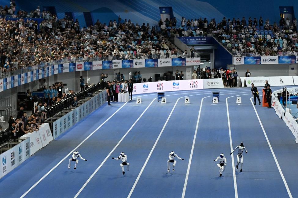 Des robots humanoïdes s'affrontent lors de la finale du 100 mètres pour petits robots, durant les deuxièmes Jeux mondiaux des robots humanoïdes, au Stade national de patinage de vitesse de Pékin, le 26 août 2026.