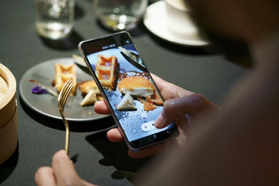À Singapour, un invité filme avec son téléphone portable un repas comprenant un nugget à base de viande de poulet. 