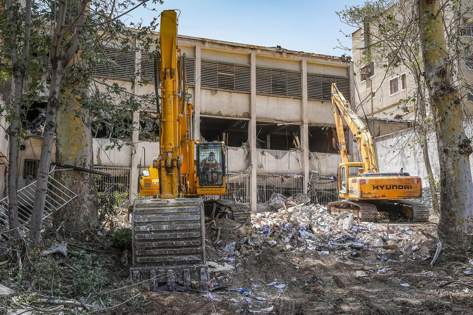 Des excavatrices sont utilisées pour dégager les décombres à l'extérieur du complexe pénitentiaire d'Evin à Téhéran, touché quelques jours auparavant par une frappe israélienne.