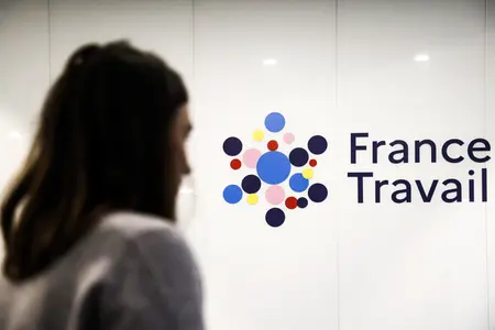 Une femme passe devant le logo de « France Travail », le nouvel opérateur du service public de l'emploi, à Paris, le 3 janvier 2024.