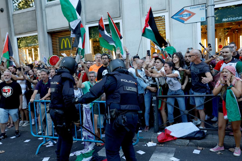 La police intervient alors que des manifestants pro-palestiniens tentent d'envahir la rue lors de la 21e et dernière étape de la Vuelta, près de la gare d'Atocha à Madrid, le 14 septembre 2025.