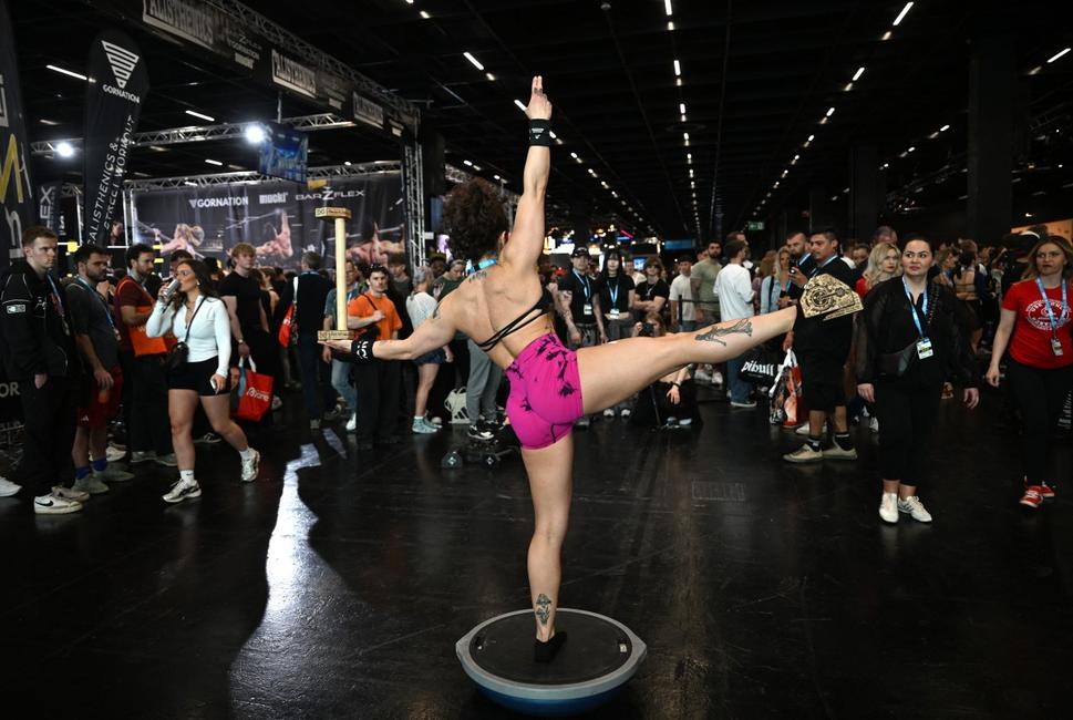 Une femme effectue des exercices d'équilibre au salon FIBO, dédié à la santé, au fitness et au bien-être, à Cologne, dans l'ouest de l'Allemagne, le 17 avril 2026.