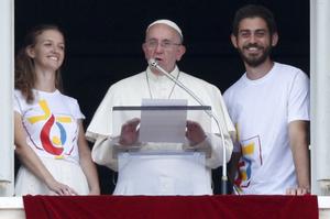 Le pape François entouré de deux jeunes polonais alors qu'il annonce l'ouverture officielle des inscriptions en ligne pour le JMJ 2016 depuis la place Saint-Pierre au Vatican le 26 Juillet 2015.
