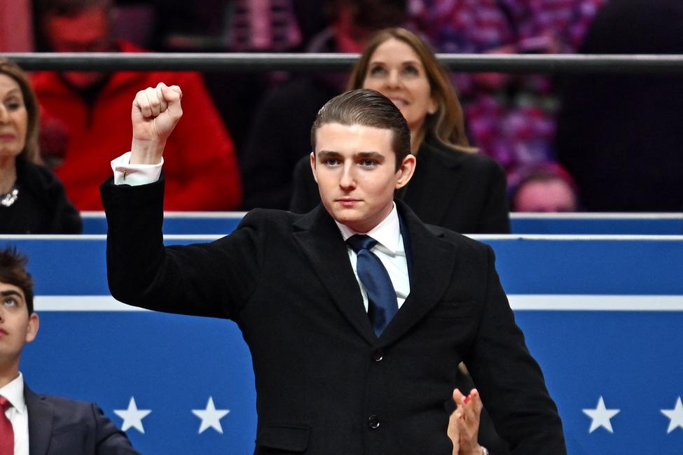Barron Trump fait un geste après avoir été salué par son père, le président américain Donald Trump, lors du défilé inaugural à la Capital One Arena, à Washington, D.C., le 20 janvier 2025.
