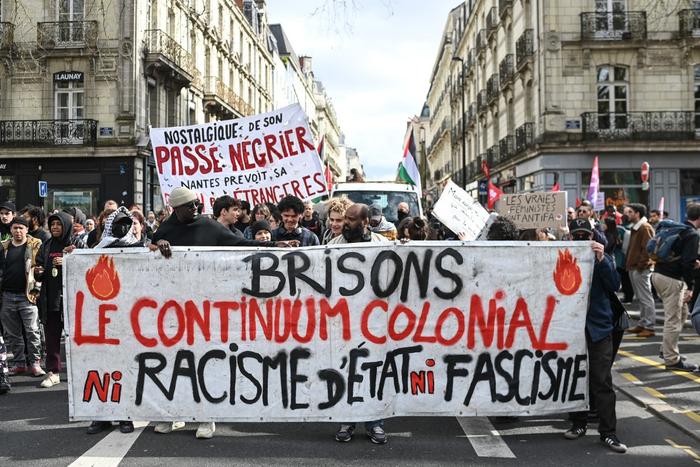 Des manifestants brandissent une banderole lors d'un rassemblement dans le cadre de la Journée internationale contre le racisme et le fascisme à Nantes le 22 mars 2025.