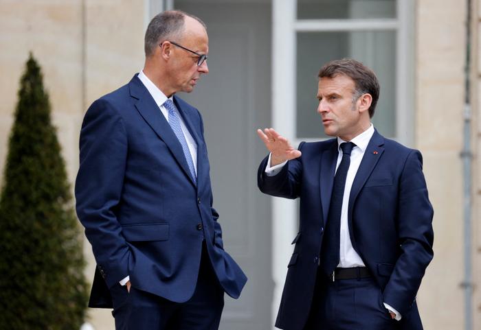 Le président français Emmanuel Macron s'entretient avec le nouveau chancelier allemand élu, Friedrich Merz, dans les jardins du palais présidentiel de l'Élysée, à Paris, le 7 mai 2025. Merz se rend en France et en Pologne ce 7 mai, dans le cadre d'une mission visant à renforcer les liens avec les voisins européens en cette période troublée.