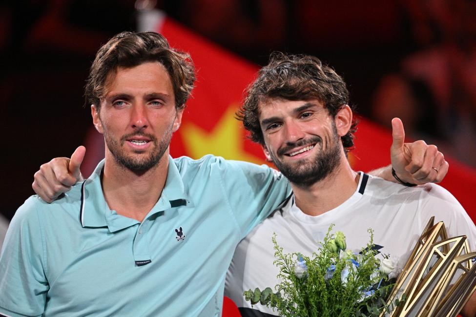 Le Monégasque Valentin Vacherot (à droite) pose avec le trophée après sa victoire contre le Français Arthur Rinderknech (à gauche) lors de la finale du simple messieurs du tournoi de tennis Masters de Shanghai à Shanghai, le 12 octobre 2025. (Photo par Hector RETAMAL / AFP)