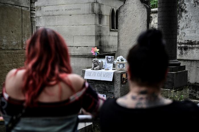 Des fans se rassemblent sur la tombe du leader des Doors, Jim Morrison, pour commémorer le 50e anniversaire de sa mort au cimetière du Père Lachaise à Paris, le 3 juillet 2021.
