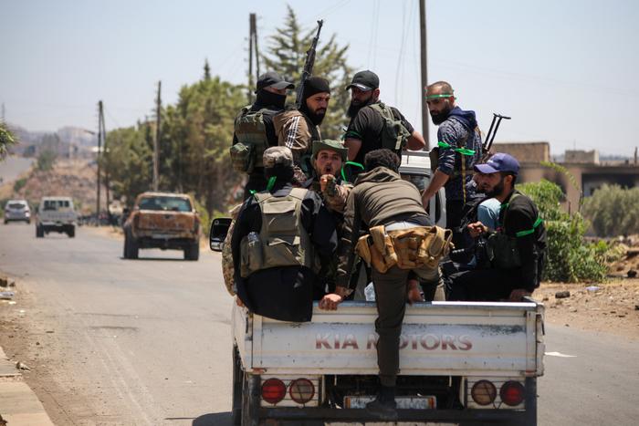 Des combattants tribaux et bédouins traversent la ville de Walga, mobilisés face à des hommes armés druzes, près de Sweida, ville majoritairement druze, dans le sud de la Syrie, le 19 juillet 2025.