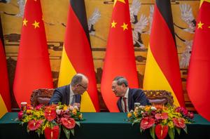 Le chancelier allemand Friedrich Merz est assis aux côtés du Premier ministre chinois Li Qiang lors d'une cérémonie de signature au Palais de l'Assemblée du Peuple à Pékin, le 25 février 2026.