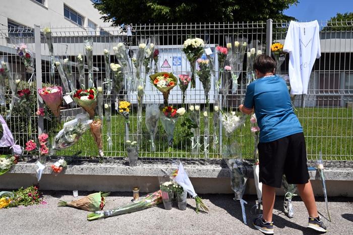 Un élève accroche des fleurs sur la clôture du collège Françoise Dolto à Nogent le 11 juin 2025, un jour après l'arrestation d'un élève de collège après avoir tué un assistant scolaire de 31 ans avec un couteau lors d'une fouille de sac.