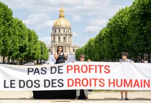 Salma Lamqaddam (g), chargée de campagne et du plaidoyer pour les droits des femmes au travail chez ActionAid France, s’exprime lors d’une action symbolique menée par Amnesty International France et d’autres ONG contre la directive européenne Omnibus, un ensemble de mesures visant à simplifier la législation sociale et environnementale applicable aux entreprises, à Paris, le 17 juin 2025. Environ quinze organisations, parmi lesquelles Amnesty International France, Oxfam France, le CCFD, Notre Affaire à Tous, Greenpeace, la FIDH, Les Amis de la Terre, Sherpa et Bloom, ont pris part à cette action. Présentée en février 2025 par la Commission européenne, la directive Omnibus a été accueillie favorablement par les organisations patronales, en particulier en France. (Image d'illustration)