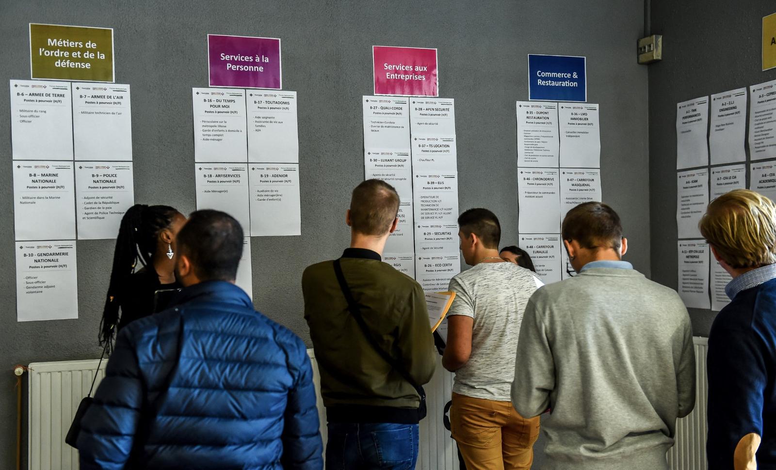 Des personnes consultent des offres d'emploi lors d'un salon de l'emploi à Tourcoing.