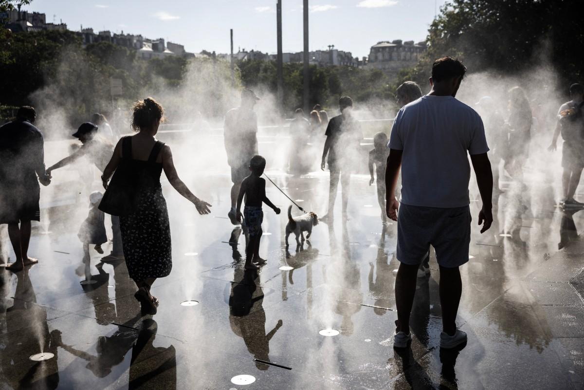 Des enfants jouent dans une aire de jeux d'eau pendant une vague de chaleur à Paris, le 10 juillet 2026.