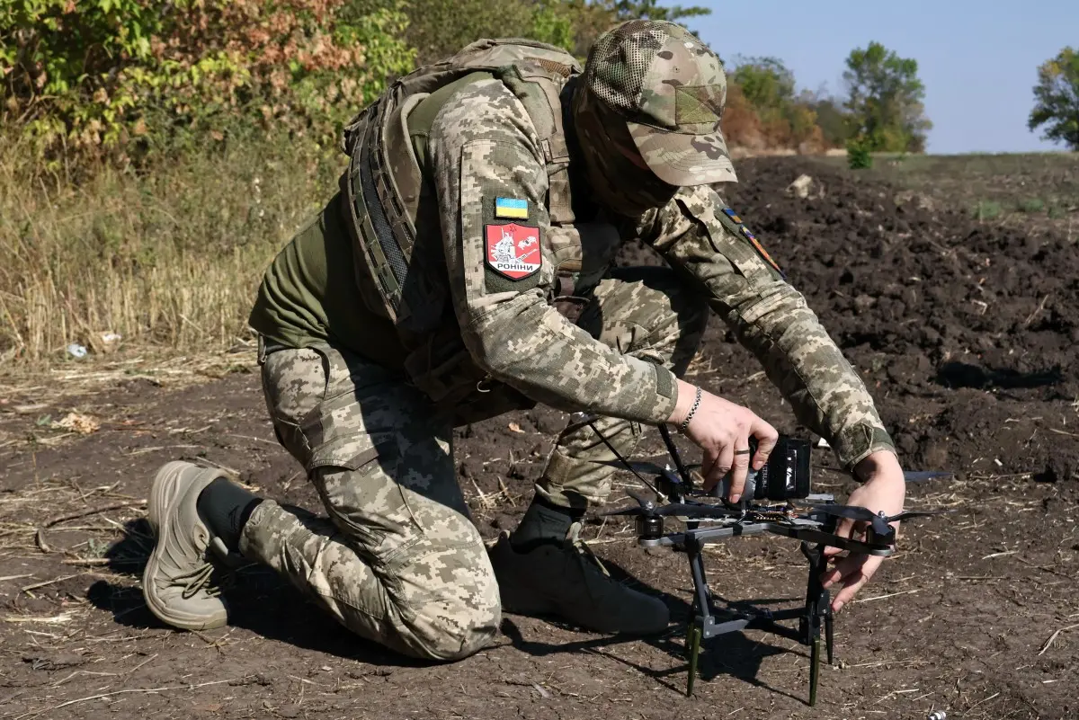 Cette photo, fournie et diffusée par le service de presse de la 65e brigade mécanisée ukrainienne le 19 septembre 2026 dans une zone indéterminée de la région de Zaporijjia, montre un militaire ukrainien préparant un drone FPV en vue d'une frappe.
