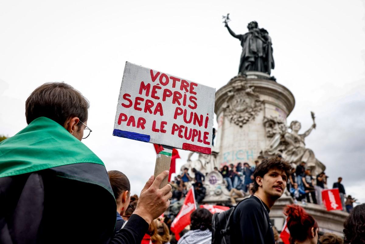 Une personne tient une pancarte sur laquelle on peut lire « votre mépris sera puni par le peuple » lors d'une manifestation sur la place de la République à Paris, le 10 septembre 2025.