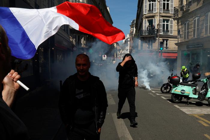 Un chauffeur de taxi brandit un drapeau français lors d’un rassemblement dans une rue de Paris, tôt le 19 mai 2025, dans le cadre d’une manifestation nationale contre les changements envisagés dans le mode de financement public des services de transport médical. (Image d'illustration)