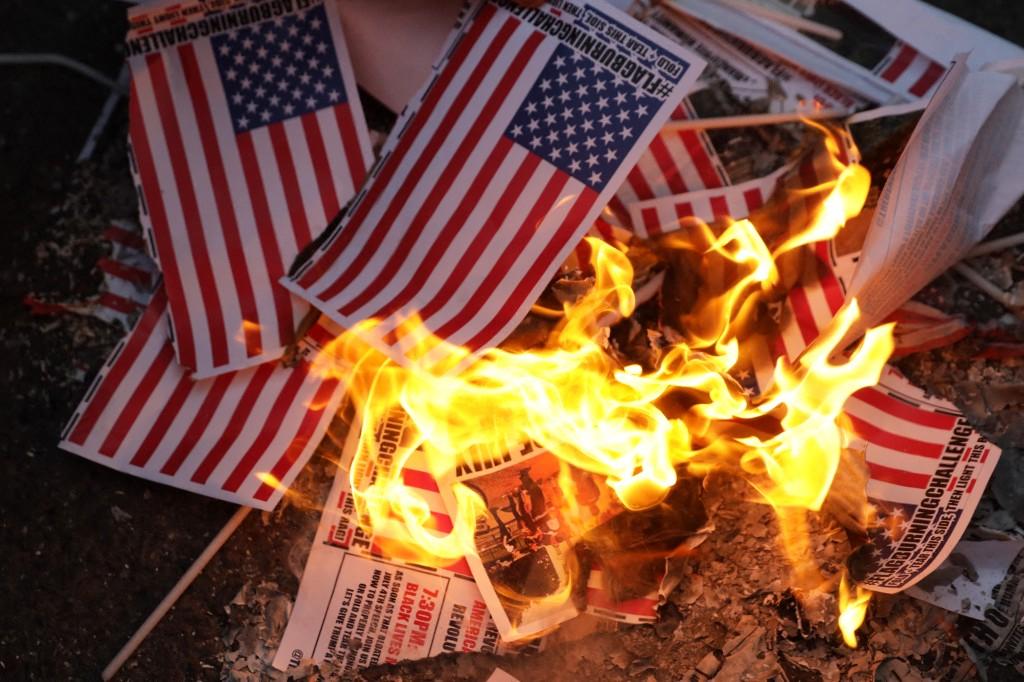 Des militants brûlent des drapeaux américains sur la place Black Lives Matter, dans le cadre de la mort de George Floyd, à Washington, le 4 juillet 2020.