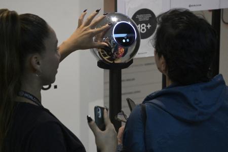 À Buenos Aires, le 22 mars 2024, une femme se fait scanner l'iris à l'aide d'un orbe, un dispositif de numérisation biométrique, en échange de la cryptomonnaie Worldcoin.