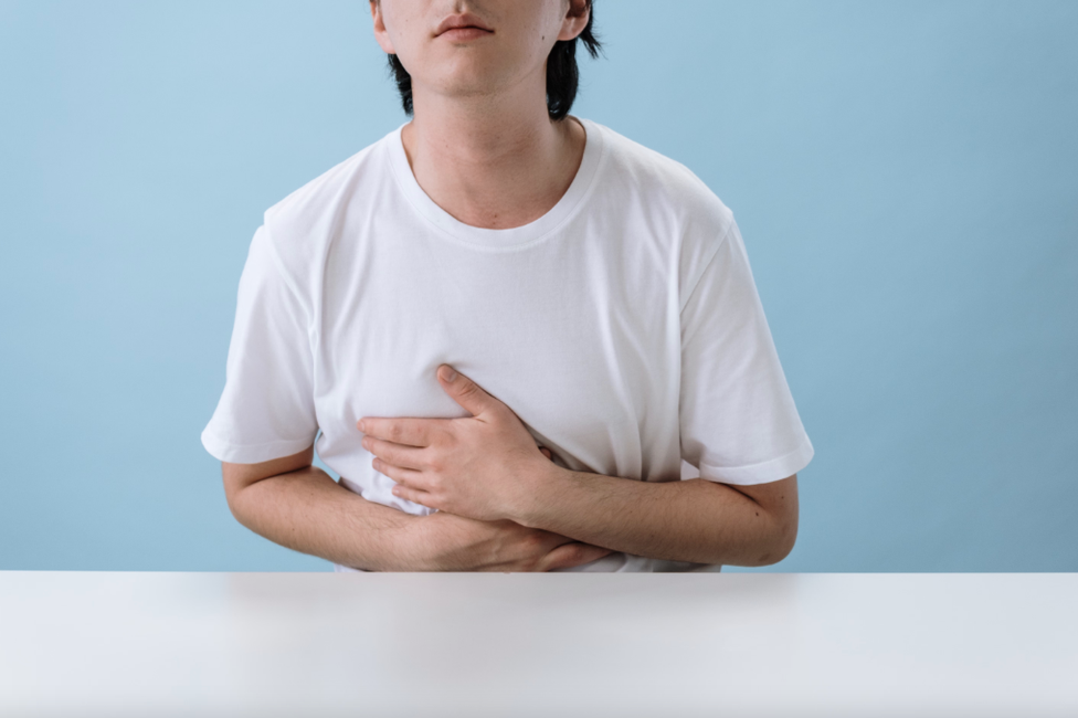 Une personne, victime de douleurs intestinales, se tient le ventre.