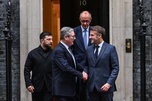 Le président ukrainien Volodymyr Zelensky (à gauche), le Premier ministre britannique Keir Starmer (deuxième à gauche), le chancelier allemand Friedrich Merz (à droite, au fond) et le président français Emmanuel Macron (à droite, au premier plan) se disent au revoir devant le 10 Downing Street après leurs entretiens dans le centre de Londres le 8 décembre 2025.