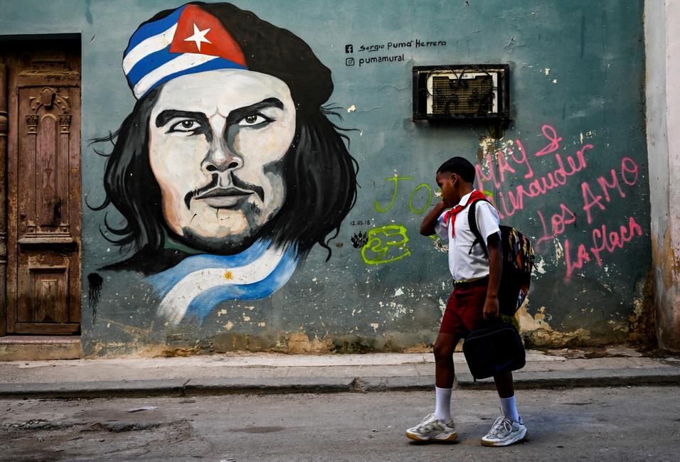 Un étudiant marche près d'un graffiti représentant le leader révolutionnaire argentin Ernesto « Che » Guevara à La Havane, le 7 octobre 2022.