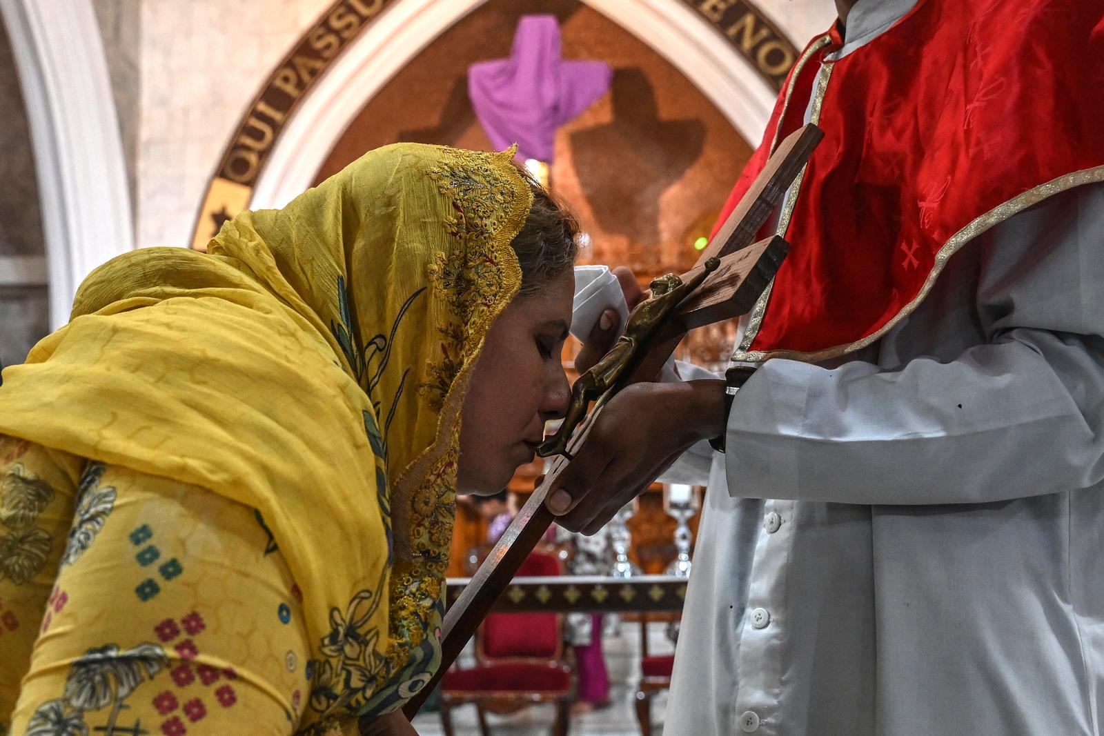 Une fidèle chrétienne embrasse une représentation de la crucifixion de Jésus-Christ lors d'un service du Vendredi saint à l'église Saint-Antoine de Lahore, le 18 avril 2025.