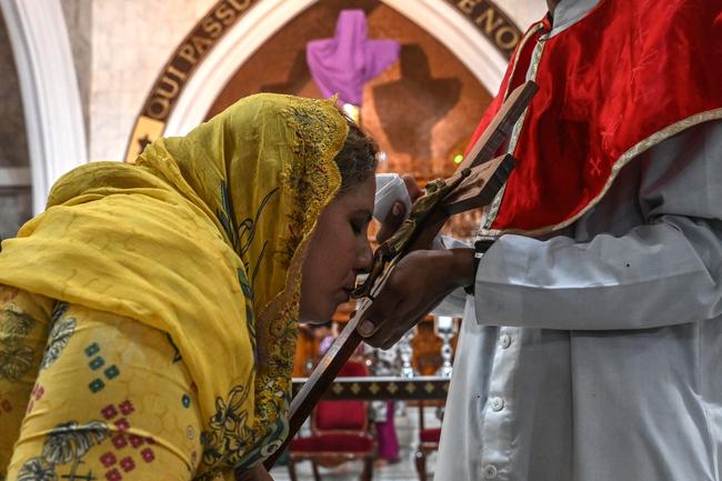 Une fidèle chrétienne embrasse une représentation de la crucifixion de Jésus-Christ lors d'un service du Vendredi saint à l'église Saint-Antoine de Lahore, le 18 avril 2025.