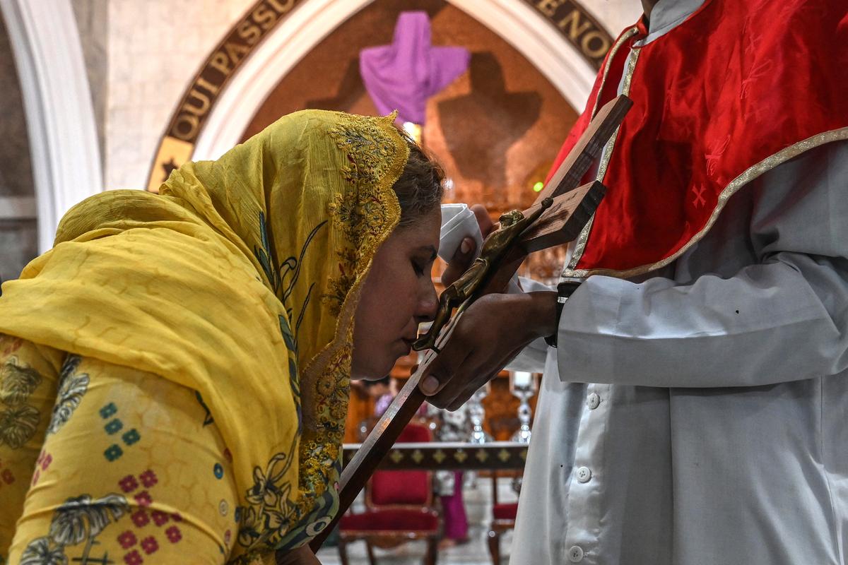 Une fidèle chrétienne embrasse une représentation de la crucifixion de Jésus-Christ lors d'un service du Vendredi saint à l'église Saint-Antoine de Lahore, le 18 avril 2025.