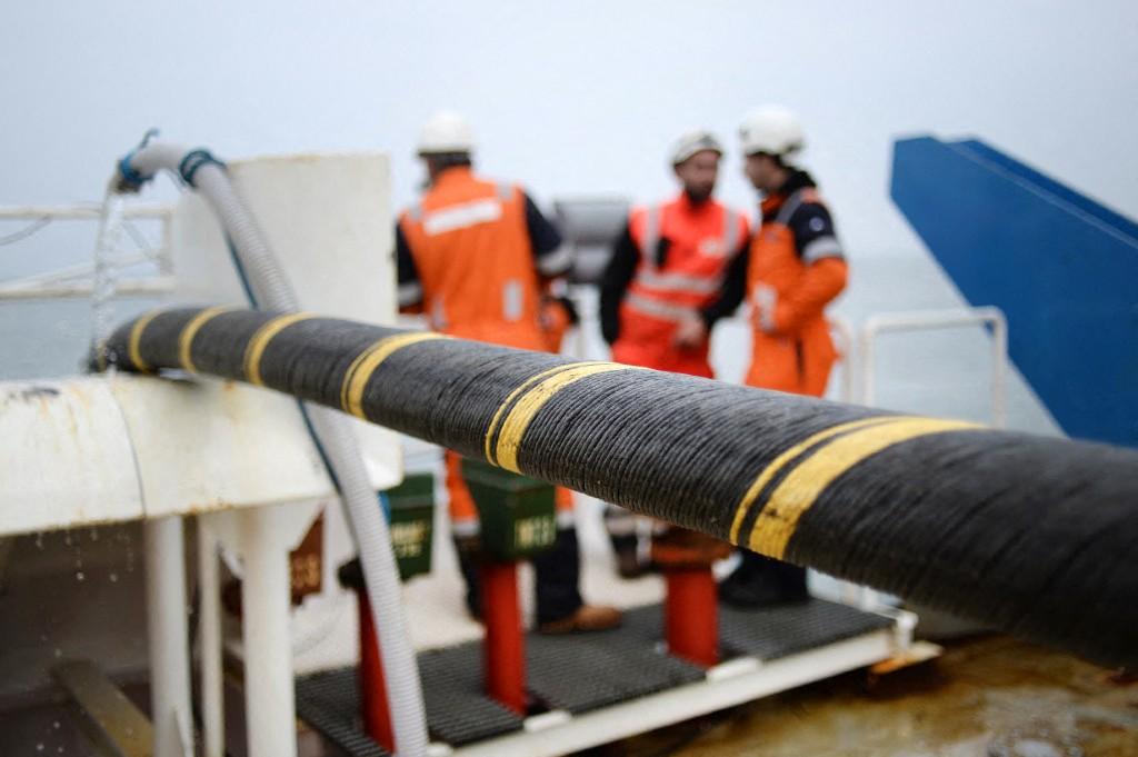 Des salariés d'ERDF (Réseau de Distribution d'Électricité France) et de la société Louis Dreyfus installent un câble électrique sous-marin et une fibre optique entre Quiberon et Belle-Ile-en-mer, dans l'ouest de la France, le 11 mars 2015.