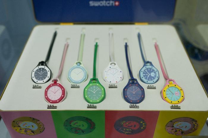 Des montres de la collection Royal Pop exposées à travers une vitrine de la façade d'une boutique de la marque horlogère suisse Swatch, à Paris, le 16 mai 2026.