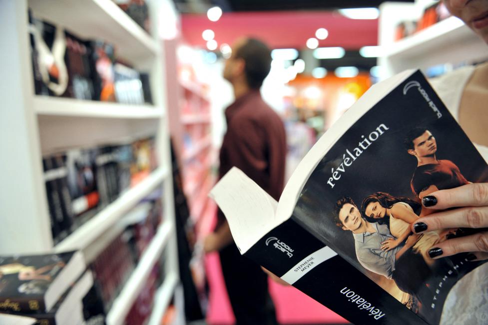 Une femme lit « Révélation », le dernier tome de la série Twilight de Stephenie Meyer, sur un stand du 27e Salon du livre et de la presse jeunesse, le 1er décembre 2011 à Montreuil, en banlieue parisienne. AFP PHOTO MEHDI FEDOUACH (Photo de Mehdi FEDOUACH / AFP)