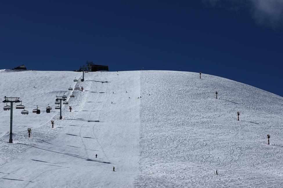 Des skieurs dévalent une piste à L'Alpe d'Huez, dans les Alpes françaises, le 17 mars 2025.