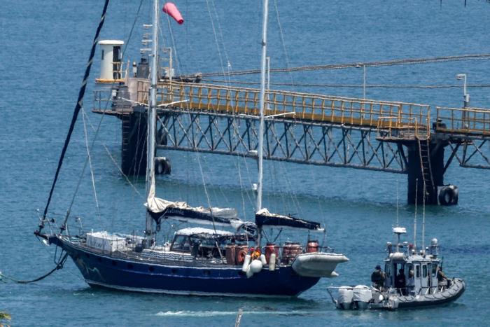 Un bateau de patrouille de la police israélienne se déplace près du voilier humanitaire Madleen alors qu'il est amarré au port sud d'Ashdod le 10 juin 2025 après avoir été intercepté la veille par les forces israéliennes.