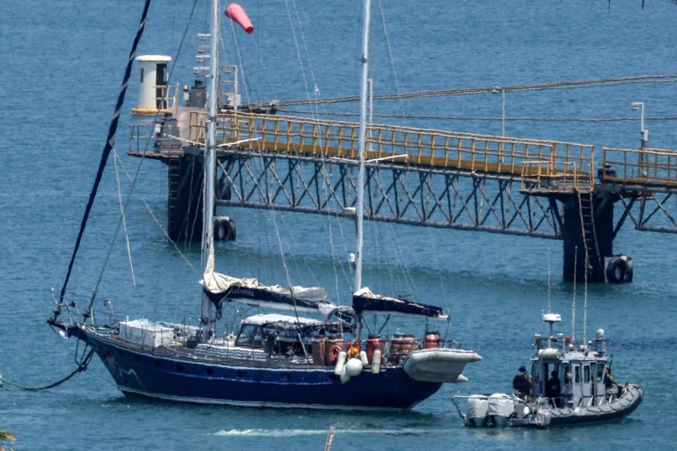 Un bateau de patrouille de la police israélienne se déplace près du voilier humanitaire Madleen alors qu'il est amarré au port sud d'Ashdod le 10 juin 2025 après avoir été intercepté la veille par les forces israéliennes.