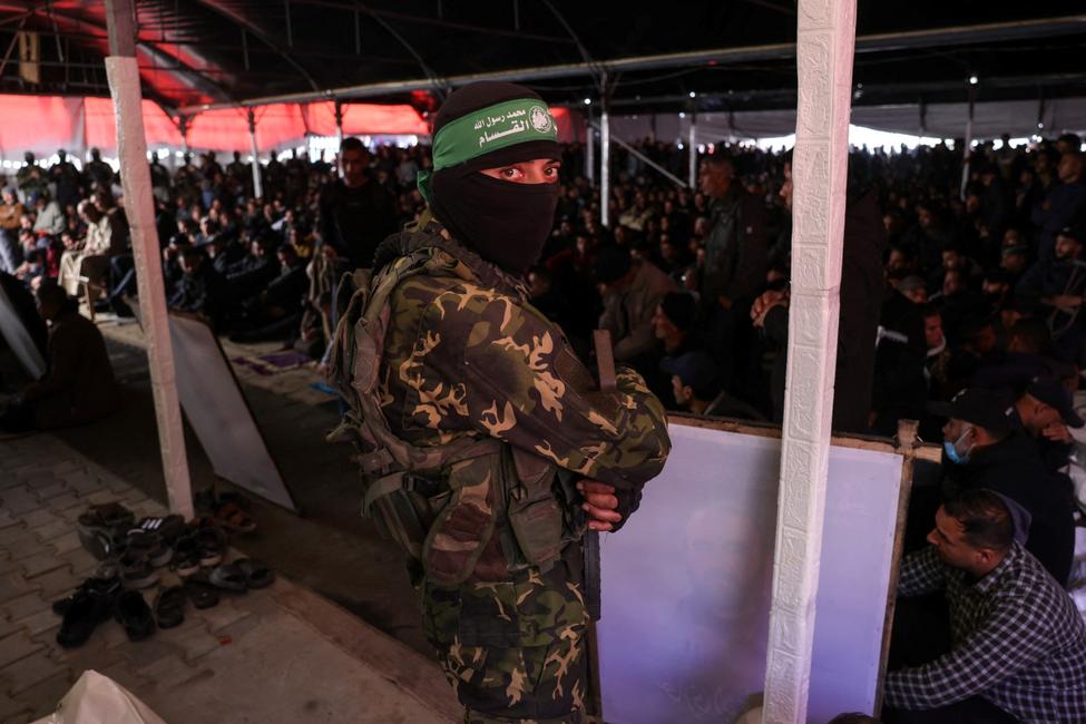 Un combattant du Hamas et des civils palestiniens lors d'une cérémonie funéraire au camp de Shati au nord de la ville de Gaza, le 28 février 2025.