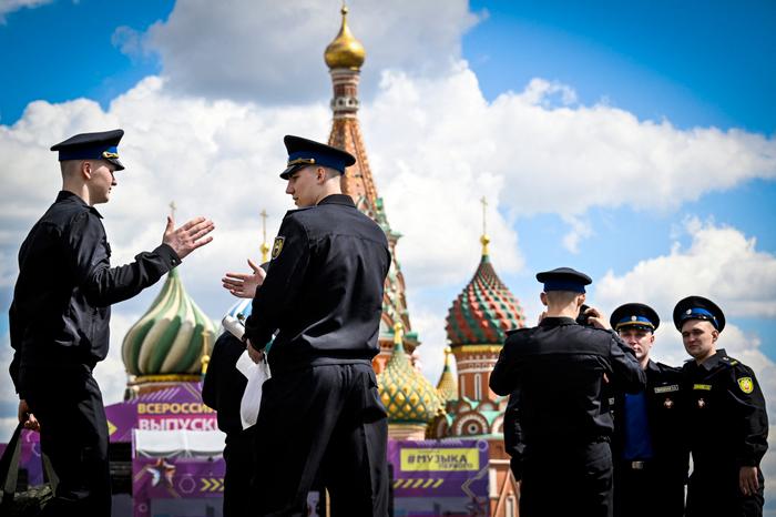 Des soldats du régiment présidentiel russe posent pour une photo et se saluent sur la place Rouge, devant la cathédrale Saint-Basile, dans le centre de Moscou, le 26 juin 2026.